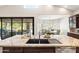 This gourmet kitchen island features a dual sink, stone countertop, stainless appliances and an open view to the outdoor living space at 2107 E Park Ave, Gilbert, AZ 85234