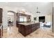 Open kitchen featuring an island, stainless steel appliances, granite countertops, vaulted ceilings and travertine floors at 2107 E Park Ave, Gilbert, AZ 85234