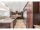 This kitchen features stone countertops, stainless steel appliances and wood cabinets, with an open layout to the dining area at 2107 E Park Ave, Gilbert, AZ 85234