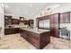 Gourmet kitchen with custom wood cabinetry, granite countertops, travertine floors, and stainless steel appliances at 2107 E Park Ave, Gilbert, AZ 85234