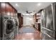 Large laundry room with stainless steel appliances, ample cabinet space, and a built-in bench with storage at 2107 E Park Ave, Gilbert, AZ 85234