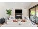 Cozy living room with a fireplace, white couches, and sliding doors to the patio at 2107 E Park Ave, Gilbert, AZ 85234