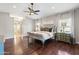 Bright bedroom with hardwood flooring, ceiling fan, and access to the ensuite bathroom at 2107 E Park Ave, Gilbert, AZ 85234