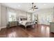 This main bedroom features hardwood floors, natural light, ceiling fan and a view to the ensuite at 2107 E Park Ave, Gilbert, AZ 85234
