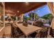 Covered patio features dining area, fireplace, and view of the pool with waterfall at 2107 E Park Ave, Gilbert, AZ 85234