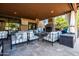 Inviting outdoor living space featuring a fireplace, comfortable seating, and a view of the trees at 2107 E Park Ave, Gilbert, AZ 85234