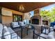 Inviting outdoor living space featuring a fireplace, comfortable seating, and a view of the trees at 2107 E Park Ave, Gilbert, AZ 85234