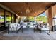 Inviting outdoor living space featuring a fireplace, comfortable seating, and a view of the trees at 2107 E Park Ave, Gilbert, AZ 85234
