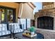 Inviting outdoor living space featuring a fireplace, comfortable seating, and a view of the trees at 2107 E Park Ave, Gilbert, AZ 85234