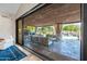 Expansive covered patio featuring comfortable seating, outdoor fireplace, chandelier, and a view of a sparkling pool at 2107 E Park Ave, Gilbert, AZ 85234