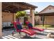 Patio with comfortable lounge seating, pillows, a pergola, stone flooring, and privacy landscape at 2107 E Park Ave, Gilbert, AZ 85234