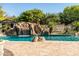 Beautiful backyard pool with rock waterfall and slide, surrounded by lush, mature landscaping at 2107 E Park Ave, Gilbert, AZ 85234