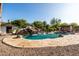 Backyard swimming pool with a rock waterfall, slide feature, and lounging area for poolside relaxation at 2107 E Park Ave, Gilbert, AZ 85234