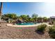 A rock waterfall feature and baja shelf lounging spots make this pool a relaxing backyard oasis at 2107 E Park Ave, Gilbert, AZ 85234