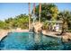 Backyard pool featuring cascading waterfall, rock features, lush palm trees, and mature foliage at 2107 E Park Ave, Gilbert, AZ 85234