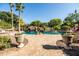 Lush backyard oasis featuring a sparkling pool, rock waterfall, and meticulously landscaped surroundings at 2107 E Park Ave, Gilbert, AZ 85234