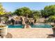 Beautiful backyard pool with rock waterfall feature, slide, and lush landscaping for ultimate relaxation at 2107 E Park Ave, Gilbert, AZ 85234