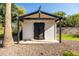 Charming backyard shed with black trim and double doors, perfect for storage or a workshop at 2107 E Park Ave, Gilbert, AZ 85234