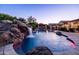 Sparkling pool with rock waterfall feature, and covered patio, perfect for relaxing at 2107 E Park Ave, Gilbert, AZ 85234