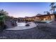 Backyard oasis with a sparkling pool, rock waterfall feature, hammock, and covered patio at 2107 E Park Ave, Gilbert, AZ 85234