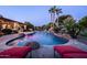 Backyard oasis features a swimming pool, mature landscaping, and rock waterfall feature at 2107 E Park Ave, Gilbert, AZ 85234