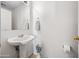 Bright bathroom with a pedestal sink, neutral walls, and decorative floral accents at 2327 E Meadow Creek Way, San Tan Valley, AZ 85140