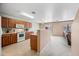 Well-lit kitchen with wood cabinets, white appliances, and adjacent dining area with sliding glass doors at 2327 E Meadow Creek Way, San Tan Valley, AZ 85140