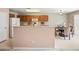 Open kitchen with wood cabinets, white appliances, and bar seating next to a cozy dining area at 2327 E Meadow Creek Way, San Tan Valley, AZ 85140