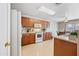 Bright kitchen features wood cabinets, white appliances, and views into the dining area through sliding glass doors at 2327 E Meadow Creek Way, San Tan Valley, AZ 85140