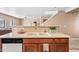 Kitchen sink with brown cabinets and a view into the living area at 2327 E Meadow Creek Way, San Tan Valley, AZ 85140