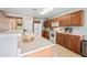 Light and airy kitchen with wood cabinets, white appliances, and breakfast bar with adjacent dining area at 2327 E Meadow Creek Way, San Tan Valley, AZ 85140