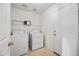 Well-lit laundry room equipped with a washer, dryer, and shelving for convenient storage at 2327 E Meadow Creek Way, San Tan Valley, AZ 85140