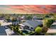 Desert home with pool and covered patio, lush green hedges, and picturesque sunset sky at 2343 E Morelos St, Chandler, AZ 85225