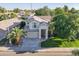 Eye-level aerial view of a two-story home with a well-manicured lawn and mature palm trees at 2421 W Indigo Dr, Chandler, AZ 85248