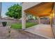 Relaxing backyard featuring covered patio, lush green lawn and mature trees at 2421 W Indigo Dr, Chandler, AZ 85248
