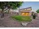 Expansive backyard featuring green lawn, mature trees, and a covered patio at 2421 W Indigo Dr, Chandler, AZ 85248