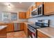 Well-lit kitchen featuring stainless steel appliances and light wood cabinetry at 2421 W Indigo Dr, Chandler, AZ 85248