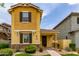 Inviting yellow home featuring a covered porch, meticulous landscaping, and great curb appeal at 2499 S Entwistle St, Gilbert, AZ 85295
