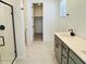 Modern bathroom featuring double vanity sinks, a walk-in closet, and a glass-enclosed shower at 25137 W Wayland Dr, Buckeye, AZ 85326