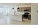 Modern kitchen featuring gray cabinets, stainless steel appliances, island, and sleek pendant lighting at 25137 W Wayland Dr, Buckeye, AZ 85326