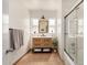 Bright bathroom featuring a wooden vanity, shower with glass door, and two windows at 28 E 14Th St, Tempe, AZ 85281