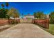 Long driveway secured by double wooden gates set between walls of brick at 28 E 14Th St, Tempe, AZ 85281