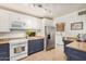 Well-lit kitchen with stainless steel refrigerator and appliances, granite counters and white and blue cabinets at 28 E 14Th St, Tempe, AZ 85281