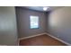 Empty bedroom featuring wood-look floors and a single window at 3526 E Piccadilly Rd, Phoenix, AZ 85018