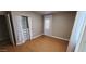 Bedroom with wood-look floors, a window, and closet with white curtains at 3526 E Piccadilly Rd, Phoenix, AZ 85018