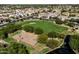Aerial view of community park with a basketball court, a lake and mature shade trees at 3664 E Narrowleaf Dr, Gilbert, AZ 85298