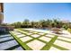 Expansive backyard featuring a lush lawn, pool with waterfall, outdoor kitchen, and patio with dining set at 3664 E Narrowleaf Dr, Gilbert, AZ 85298
