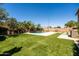 Expansive backyard showcasing lush lawn, pool with waterfall feature, and outdoor entertainment areas at 3664 E Narrowleaf Dr, Gilbert, AZ 85298