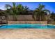 A captivating backyard showcasing a pool with a decorative stone waterfall and lush palm trees at dusk at 3664 E Narrowleaf Dr, Gilbert, AZ 85298