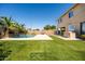 Lush backyard with well-manicured lawn, sparkling pool, and outdoor kitchen, perfect for entertaining at 3664 E Narrowleaf Dr, Gilbert, AZ 85298